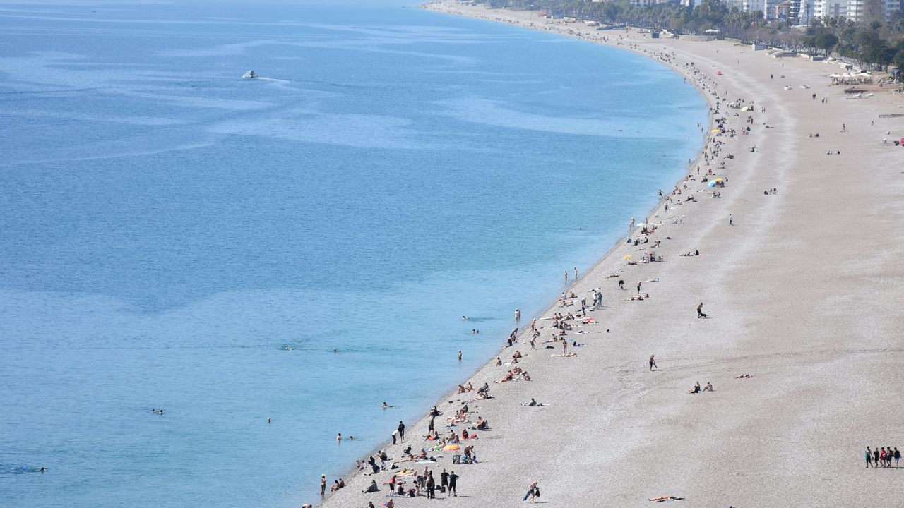 Antalya'da deniz sezonu başladı! Güzel havayı fırsat bilenler soluğu sahilde aldı!